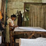 Artisan applying the first layer of wax to a silk Kinsfolk scarf